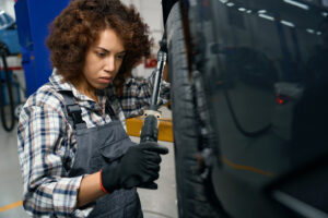 young-auto-repairman-in-work-clothes-looks-wheel-o-2023-04-10-20-05-26-utc 2